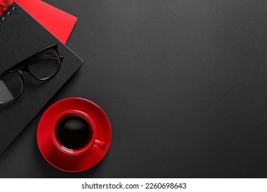 Red cup with aromatic coffee, notepads and glasses on black background, flat lay. Space for text - Shutterstock ID 2260698643