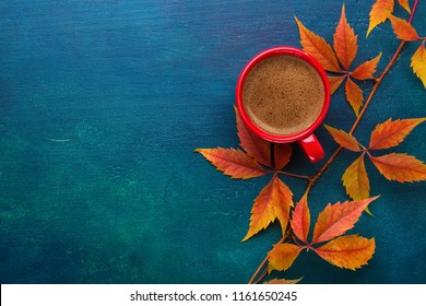  Red cup of black coffee and branch of colorful autumn leaves  (Virginia creeper)  on a dark blue-green wooden table.  Flat lay  - Powered by Shutterstock