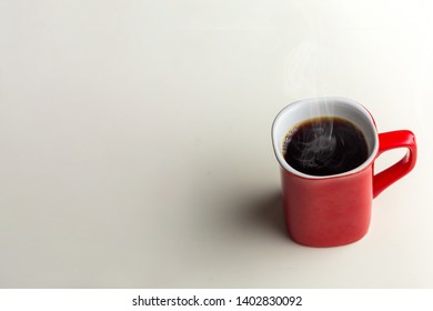 A Red Cup Of Coffee On A White Desk Background