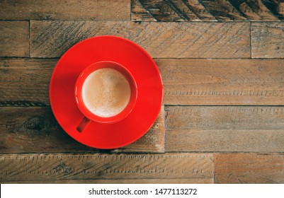 Red Cup Of Coffee On A Wooden Table. Top View