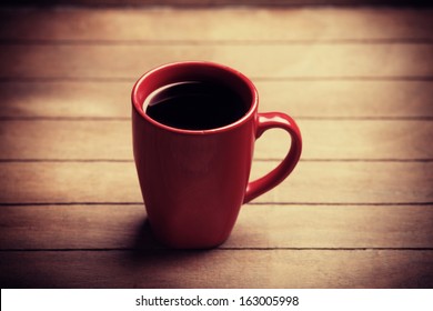 Red Cup Of Coffee On Wooden Table