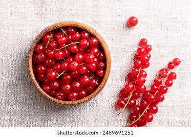 Red currant berries, fresh ripe and raw redcurrants in a wooden bowl on linen fabric. Ready to eat spherical edible fruits of Ribes rubrum, sweet fruits with an intense red color. Close-up food photo. - Powered by Shutterstock