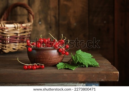 red currants in a clay bowl on the table. berries.