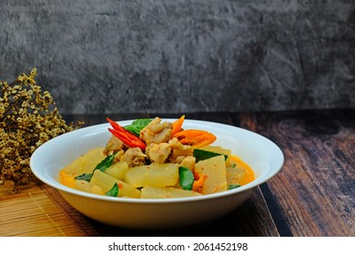 Red Curry Chicken With Winter Melon And Coconut Milk In White Bowl On Wooden Table. Authentic Thai Food.