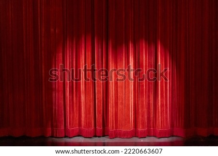 Red curtains on a small theater, with a spotlight to the anticipation of the show.