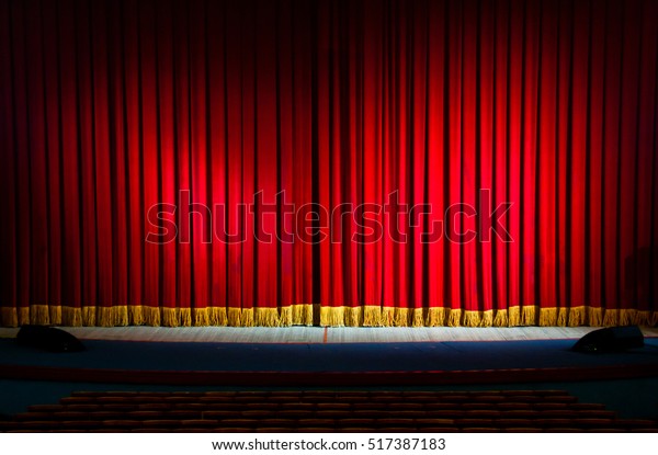 Red curtains in a\
theater scene of the show. Closed theater curtain of red velvet,\
texture, background.