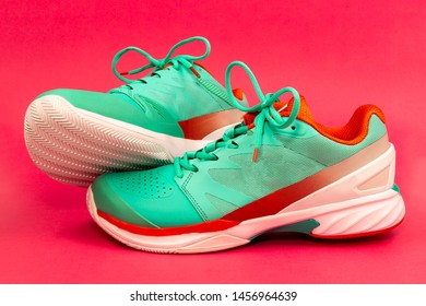 Red, Cyan, White Pair Of New Tennis Shoes In Studio Isolated On A Purple Background.