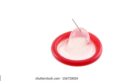 Red damaged condom with a pin hole in it isolated on white background. Ideally representing the sexual risk of using breakable condom. 