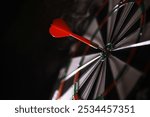 Red Dart Hitting Bullseye on Dartboard - Precision, Success, and Achievement Concept