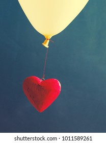 Red decorative heart on a balloon against a dark background. Romantic image by St. Valentine's Day