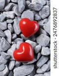 Red decorative hearts on grey stones, top view