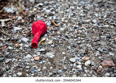 Red Deflated Baloon Left On The Ground