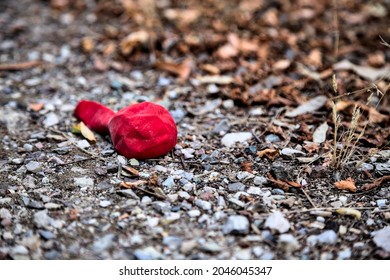 Red Deflated Baloon Left On The Ground