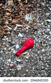 Red Deflated Baloon Left On The Ground