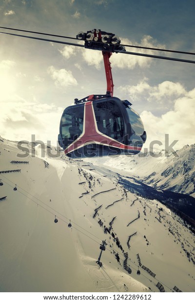 red detailed cable car lift way to snowy mountains\
at austria ischgl