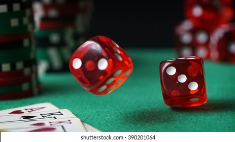 Red dice, casino chips, cards on green felt