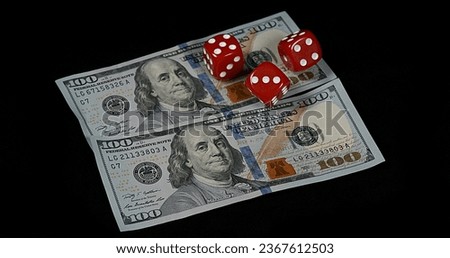 Red Dice rolling on Dollar Bills against Black Background