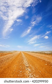 Red Dirt Road In The Australian Outback, Under A Blazing Hot Blue Sky.
