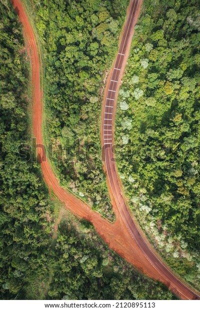 red dirt road and paved road in the middle of\
the Misiones jungle of\
Argentina