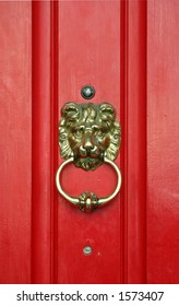 Red door with brass lion head knocker.