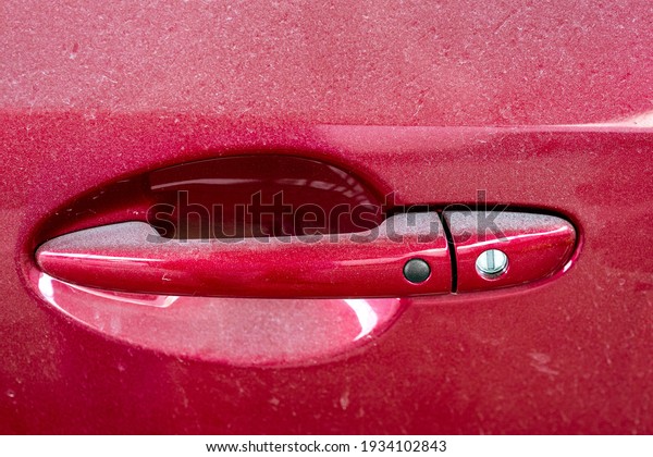 red door with handle and a keyhole and smart\
keyless access button close-up, abandoned dirty car covered with a\
layer of dust, nobody.