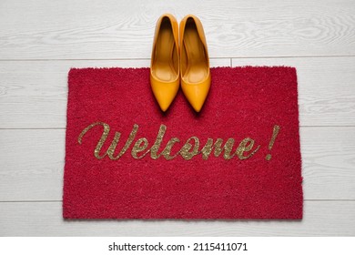 Red Door Mat With Heels On White Wooden Floor