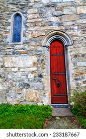 The red door to the medieval stone church