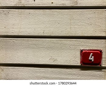 Red Door Number 4 On Old White Wooden Background