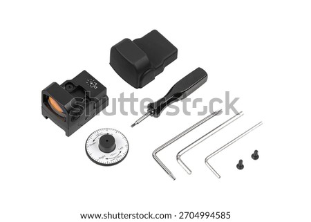 A red dot sight kit including the optic, protective cover, adjustment tools, screws, and wrenches.