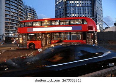 Red double decker bus in motion blur in London night traffic. Blank bilboard on the side. UK