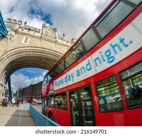 Red Double Decker Bus speeding up under Tower Bridge.