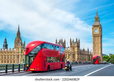 Red double-decker buses pass by Big Ben and the Houses of Parliament on Westminster Bridge. London, England