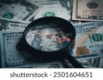 Red down arrow inside of magnifier glass and USD dollar banknote for United States of America or USA economic recession concept.