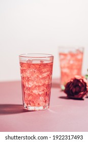 Red Drink Cocktail Or Lemonade With Ice In A Glass On Pink Background.