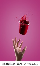 The Red Drink Splashes Out Of A Paper Cup