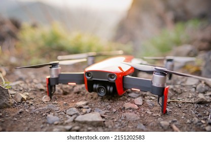 Red drone, quadcopter new drone technology. Ready to explore nature. Fly in the while walking in the mountains. Shooting travel content on a drone.