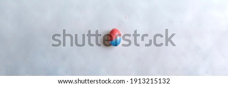 Red easter egg on paper gray background with copyspace. Banner of macro moody minimalistic decoration concept. Stock photo.