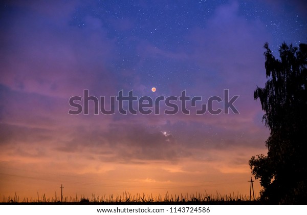 Red eclipse of the\
moon in the starry sky