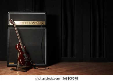 Red electric guitar and classic amplifier on a dark background                         - Shutterstock ID 369109598