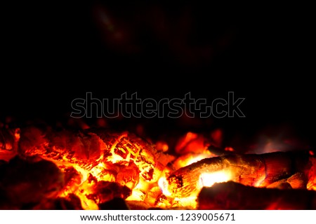 Red ember on black background. Hot red embers background.