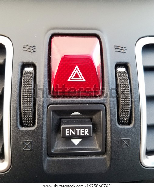 Red emergency\
blinker button on car\
dashboard.