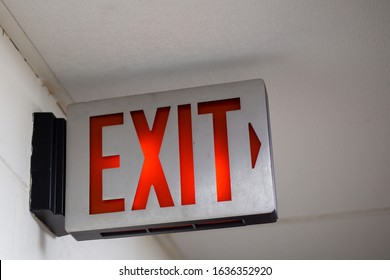 red emergency exit sign in the dark room. illuminated office exit sign
