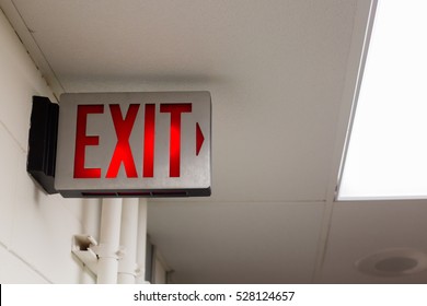 red emergency exit sign in the dark room. illuminated office exit sign.