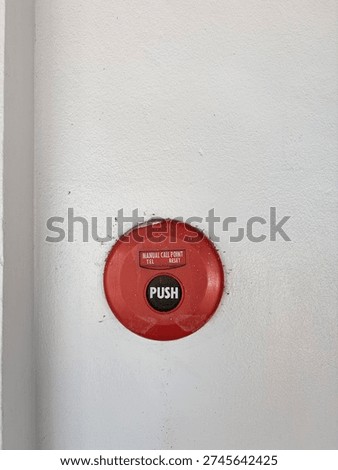 Red emergency push button on wall.