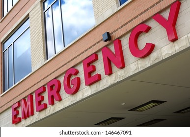 Red emergency room sign on the side of hospital with windows