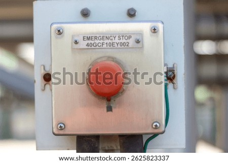 Red emergency stop button close-up on industrial equipment. Safety control switch.