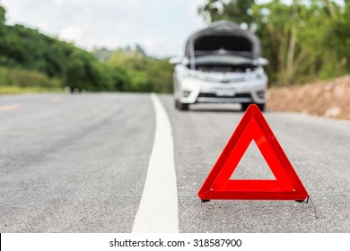 Red Emergency Stop Sign And Broken Silver Car On The Road