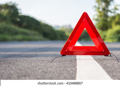 Red emergency stop sign and broken silver car on the road - Shutterstock ID 410488807