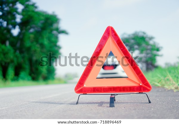 Red emergency stop sign and broken white SUV car\
on the road.red warning triangle on asphalt road.Emergency stop\
concept.
