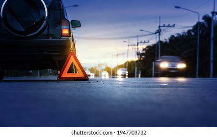 Red emergency stop sign (red triangle warning sign) and broken black SUV car  on country road. - Shutterstock ID 1947703732